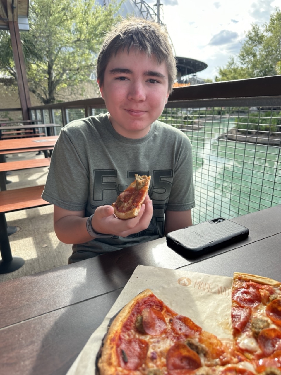 Teenager enjoying pizza at Walt Disney World during a family vacation.