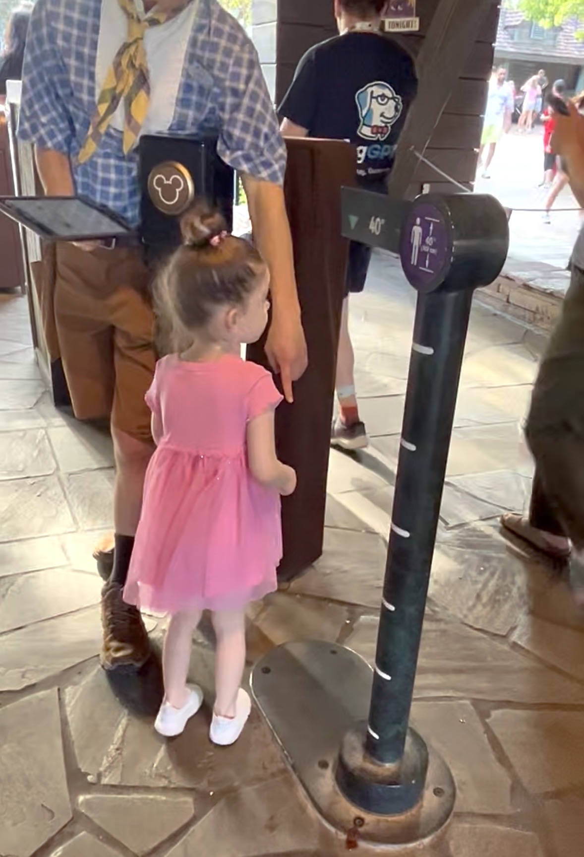 Toddler being measured at a height requirement sign at Walt Disney World